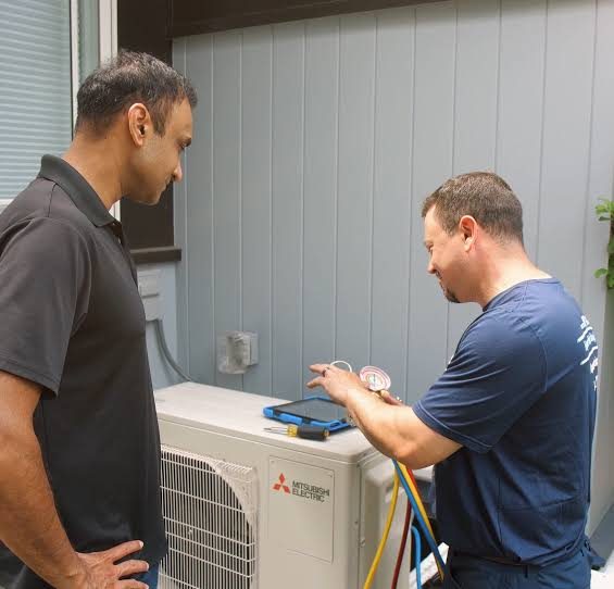 Homeowner discussing air conditioning service options with a technician