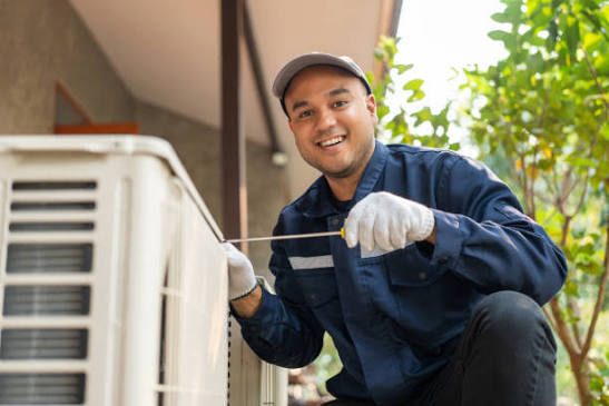 HVAC technician servicing a residential outdoor air conditioning unit